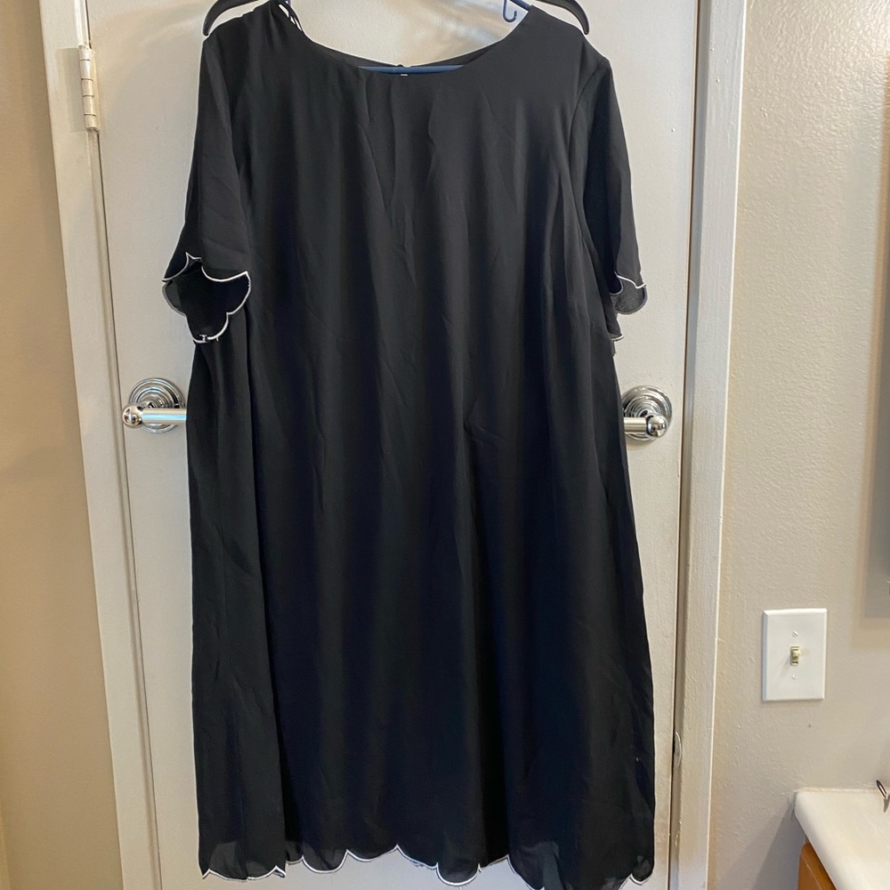 Black dress with slightly distressed scalloped sleeves and edges.